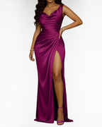Woman wearing an elegant burgundy sleeveless cowl neck maxi dress with a draped waist and thigh-high slit